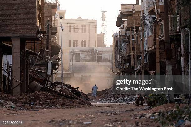 People pass through a destroyed section of Omdurman, Sudan on May 25, 2025. Ravaged by civil war for more than two years, pockets of famine are...