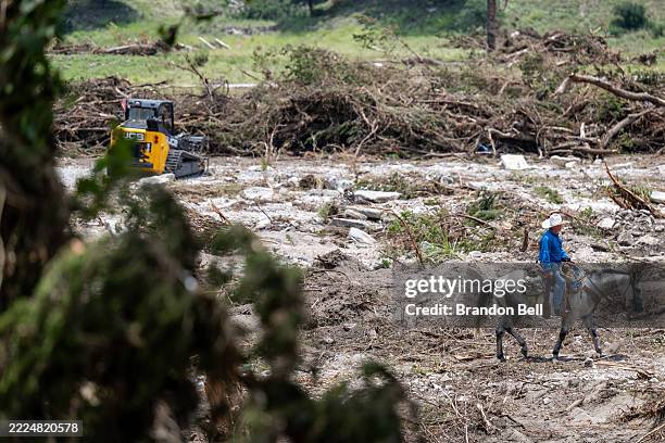 Person on horseback performs a search and rescue operation on July 12, 2025 in Hunt, Texas. More than 160 people are still missing after storm cells...