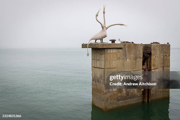 Large sculpture titled 'Dolphins' by artist Laure Prouvost mounted on the large concrete plinth-like structures for the Folkestone Triennial 2025...