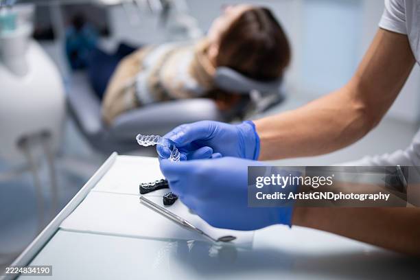 hands of dentist holding dental aligner - aparelho dentário imagens e fotografias de stock
