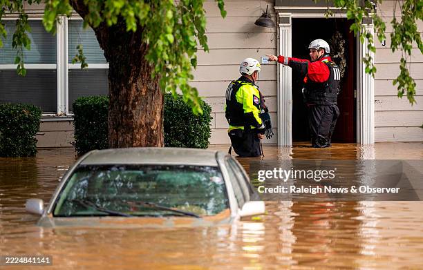 Water rescue unit with the Durham Fire Department knocks on doors at Rippling Streams Townhomes in the Old Farm neighborhood along the Eno River in...