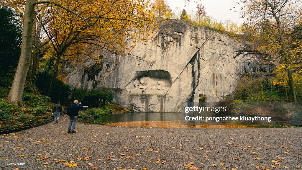 Lion monument with tourists in Luzern, Switzerland.