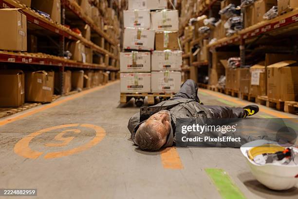 man injured on job site – warehouse accident scene with worker on ground - unconscious stock pictures, royalty-free photos & images