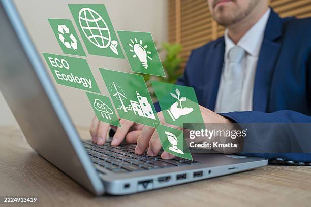 businessman using laptop with a virtual carbon reduction icons for climate change to limit global warming and sustainable development and green business. - economía verde fotografías e imágenes de stock