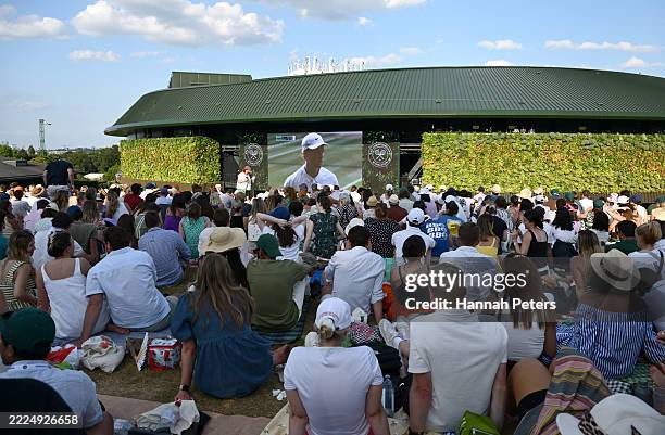 Spectators sit on The Hill as they watch the Gentleman's Singles Final on the big screen on day fourteen of The Championships Wimbledon 2025 at All...