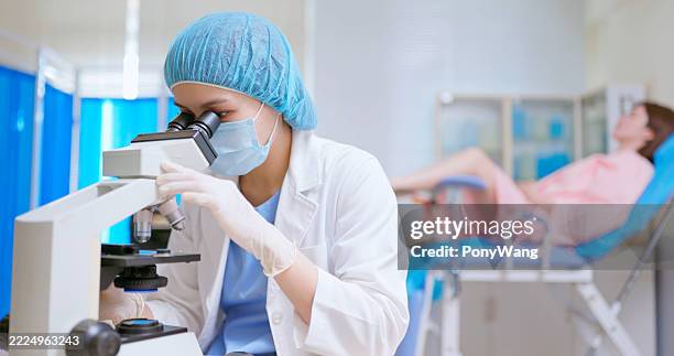 asian doctor microscope cervical smear sample clinic - cervical cancer stock pictures, royalty-free photos & images