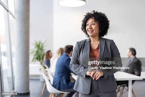 confident leader promoting teamwork in a modern office - businesswear stock pictures, royalty-free photos & images