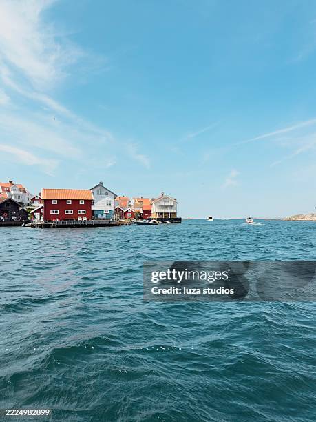 malerisches küstendorf mit charmanten häusern und leuchtend blauem wasser - mit mobilgerät aufgenommen stock-fotos und bilder