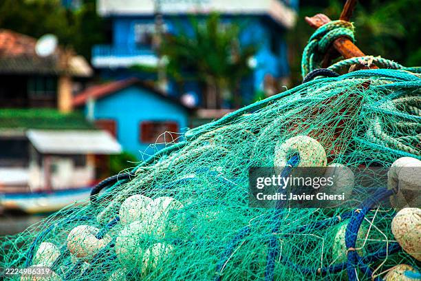 fishing nets and houses in the background. fishing village. barra da lagoa, florianópolis, santa catarina, brazil. - florianopolis stock-fotos und bilder