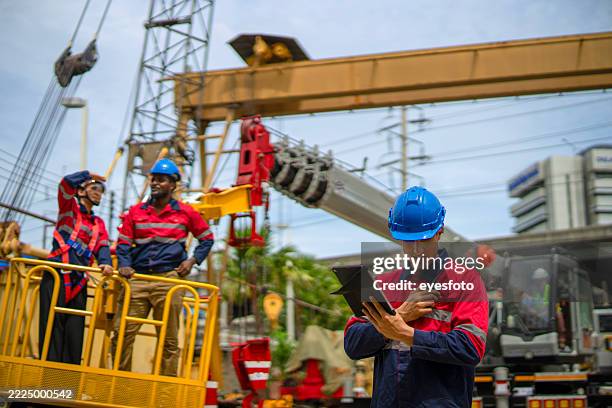 ingenieure arbeiten auf der baustelle. - mobiler kran stock-fotos und bilder