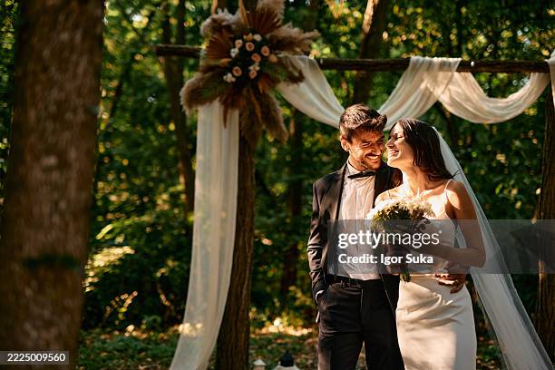 couple heureux souriant lors d’une cérémonie de mariage dans une forêt - cérémonie du mariage photos et images de collection