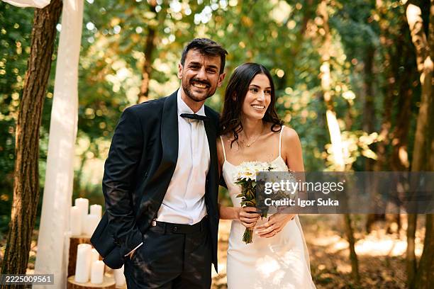 coppia felice sorridente durante la cerimonia di nozze nella foresta - wedding planning foto e immagini stock