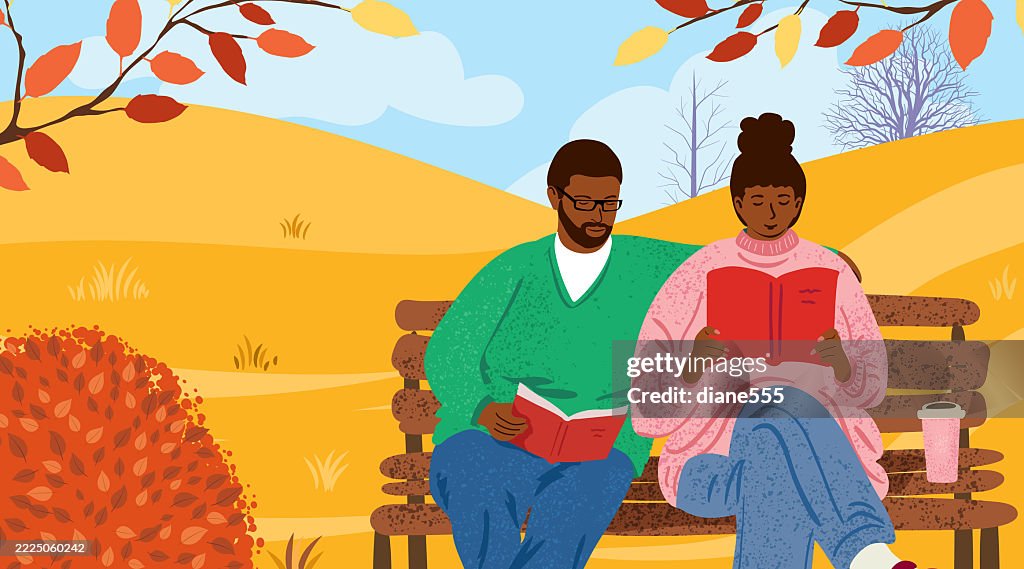 A Woman & Man Read in The Park In Autumn