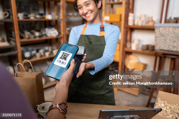 customer paying with smartphone, scan qr code at pottery shop. - qr code stockfoto's en -beelden
