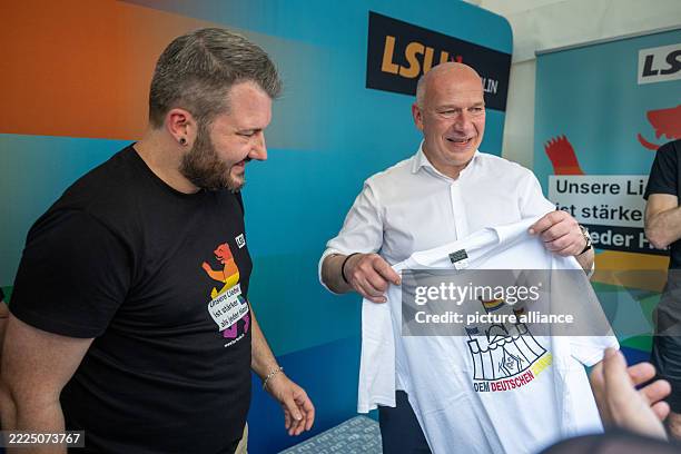Kai Wegner , Governing Mayor of Berlin, receives a T-shirt with the inscription "Dem Deutschen Zirkus" with a caricature of Chancellor Merz with a...