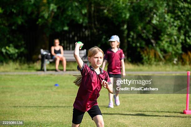 little girl with hearing aid throwing ball fielding in cricket practice - throwing stock pictures, royalty-free photos & images