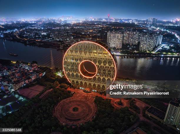 guangzhou circle mansion: iconic, illuminated doughnut building lights up china's night skyline. - guangzhou stock pictures, royalty-free photos & images