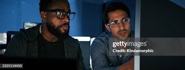 black african american and white latin man, software engineer developer use computer work on program coding together at home office. programming language development technology, freelance job at night - cloud native stock pictures, royalty-free photos & images