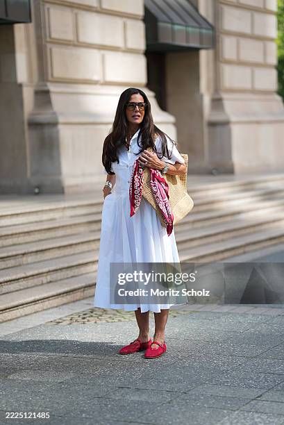 Angelika Hanel is seen wearing a white short-sleeved shirt midi dress with a flared silhouette and soft pleating from Erika Cavallini; a pair of...