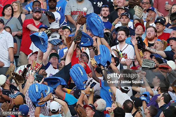 Fans reach for a ball during the Home Run Derby at Truist Park on July 14, 2025 in Atlanta, Georgia.