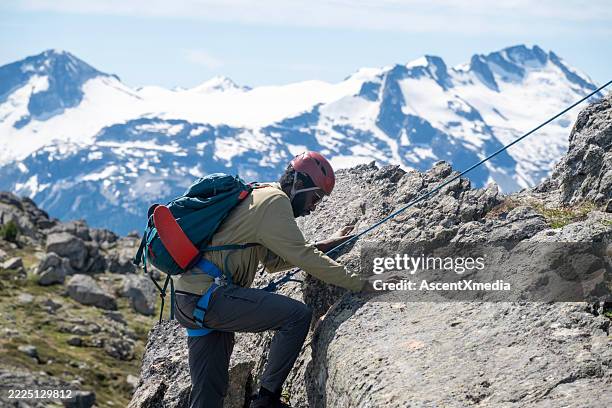 climbing guide leads guest on mountain ridge - difficult journey stock pictures, royalty-free photos & images