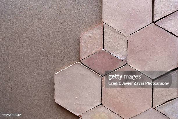 pink hexagonal terracotta tiles creating a geometric pattern on a brown surface - tessellation stock pictures, royalty-free photos & images