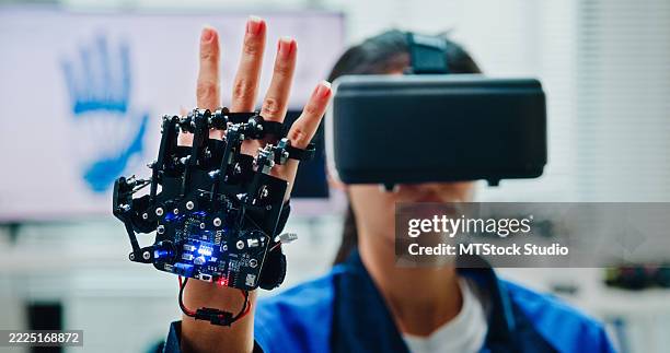 closeup young female engineer using virtual reality to design and control robotics arm in tech lab. smart glasses analyze, and simulate ai and automated systems. ai and robotics development. - studente stockfoto's en -beelden