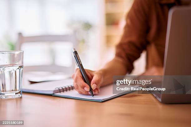 woman writing notes on notebook at home office desk - obscured face stock pictures, royalty-free photos & images