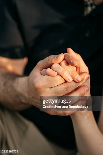 couple holding hands showing love and commitment - engagement ring stock-fotos und bilder