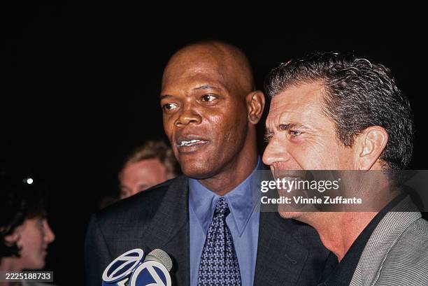 American actor Samuel L Jackson, wearing a black blazer over a blue shirt with a blue-and-dark blue, and American actor and film director Mel Gibson,...