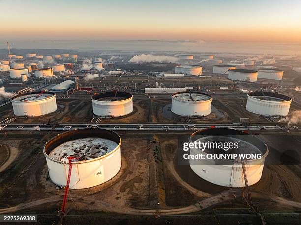 aerial view of fawley oil refinery emitting smoke and steam at sunset - fuel storage tank stock pictures, royalty-free photos & images