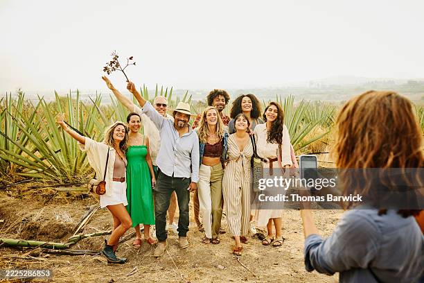 wide shot woman taking group portrait with tour guide at agave farm - green hat stock pictures, royalty-free photos & images