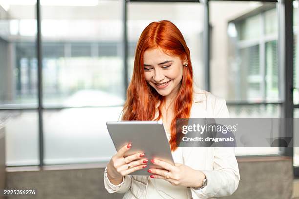 young businesswoman using digital tablet in modern office - white dress stock pictures, royalty-free photos & images