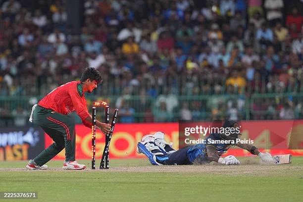 Pathum Nissanka of Sri Lanka dives to make his mark while Mahedi Hasan of Bangladesh takes the bells off during game three of the T20 series between...