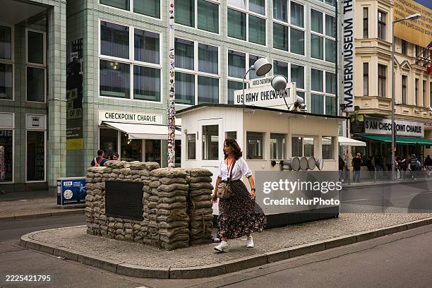 People walk past the iconic Checkpoint Charlie in Berlin, Germany, on July 15, 2025. Checkpoint Charlie is the Western Bloc's name for the best-known...