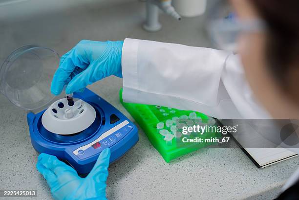 primer plano de un técnico de laboratorio cargando microcentrífugas para la preparación de muestras en el laboratorio de biociencias - biochip equipo de laboratorio fotografías e imágenes de stock