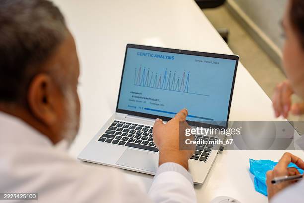 científico analizando datos genéticos en una computadora portátil en el laboratorio - biochip equipo de laboratorio fotografías e imágenes de stock