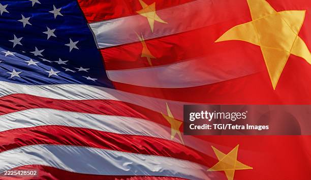 american flag and chinese flag super-imposed over each other - chinese flag stock pictures, royalty-free photos & images