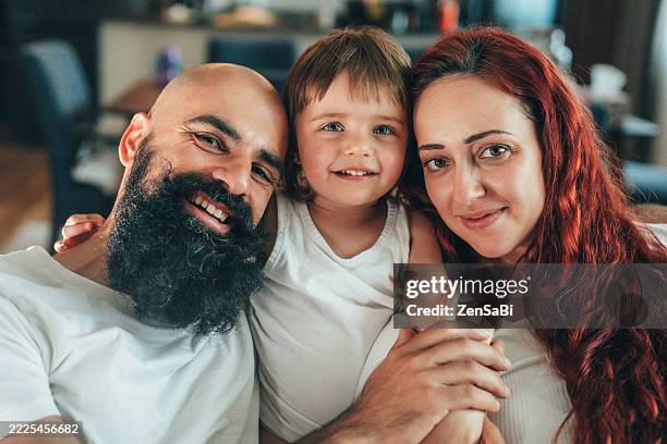 une jeune famille heureuse qui profite de moments de qualité ensemble à la maison - masculinité moderne photos et images de collection