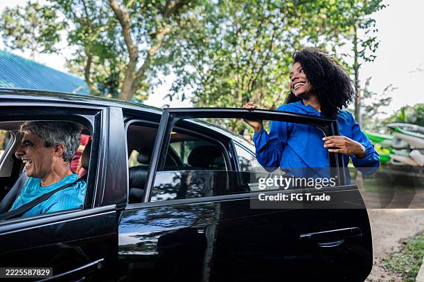 mid adult woman getting out of the car - car door stock pictures, royalty-free photos & images