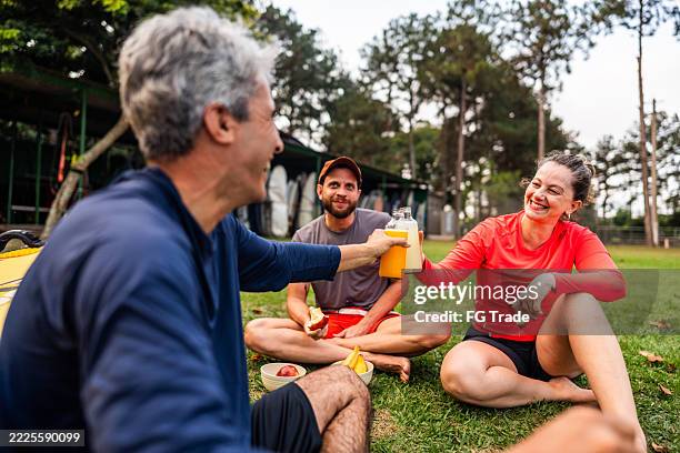 friends toasting with juice bottles outdoors - cold drink stock pictures, royalty-free photos & images