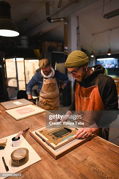 focused craftsman mounting a silkscreen printing frame in his workshop - screen print stock pictures, royalty-free photos & images