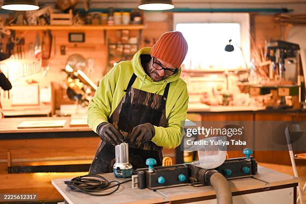 carpenter attaching bit to router in workshop - circulaire economie stockfoto's en -beelden