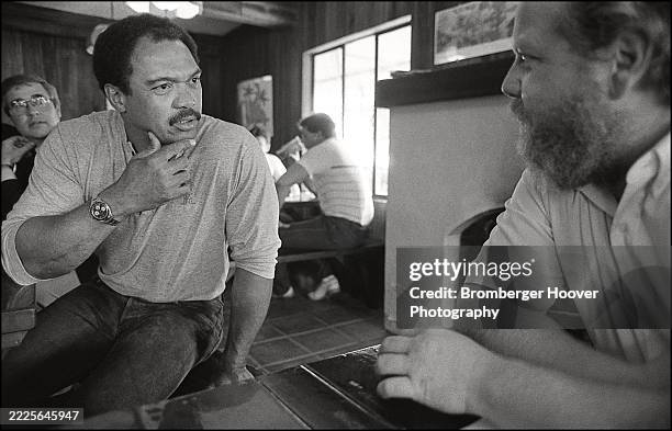 American retired baseball player Reggie Jackson talks with an unidentified man in a diner, Palo Alto, California, October 7, 1987.