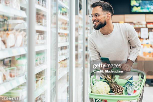 handsome man shopping in supermarket - buy online pick up in store stock pictures, royalty-free photos & images