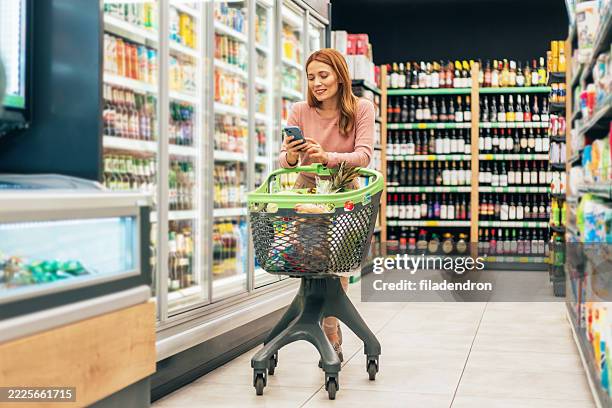 woman shopping in supermarket. - buy online pick up in store stock pictures, royalty-free photos & images