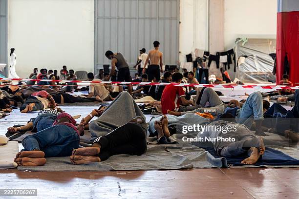 General view shows the temporary hosting site for refugees and migrants, with many sleeping on the floor of the expo pavilion, outside the city of...