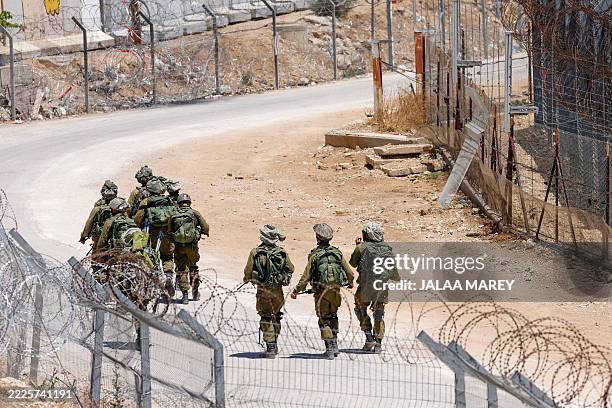 Israeli troops patrol the border fence with Syria near the Druze village of Majdal Shams in the Israel-annexed Golan Heights on July 23, 2025....