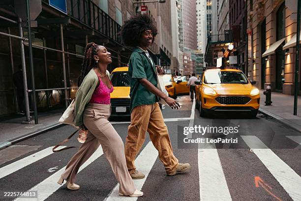 two friends in new york city - couple crossing street stock pictures, royalty-free photos & images