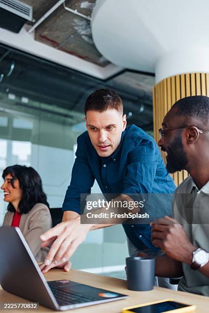 team collaborating in a creative office environment with laptops and enthusiasm - problem solving stock pictures, royalty-free photos & images